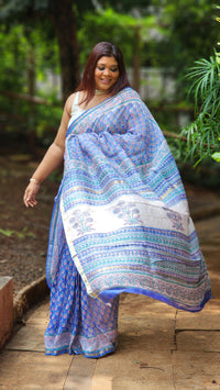 Blue Chanderi silk cotton saree with white Bagru handblock floral motifs and zari border, lightweight and handcrafted.
