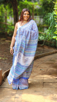 Blue Chanderi silk cotton saree with white Bagru handblock floral motifs and zari border, lightweight and handcrafted.
