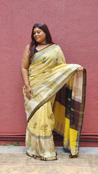 Yellow silk cotton saree with black Bagru handblock stripes, handcrafted and bold, perfect for everyday elegance.