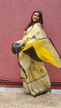Yellow silk cotton saree with black Bagru handblock stripes, handcrafted and bold, perfect for everyday elegance.
