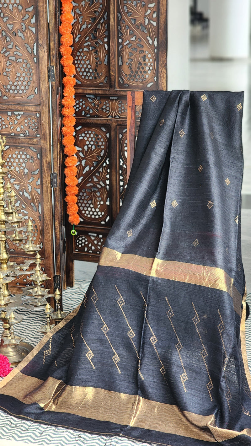 Black matka silk saree with gold zari butta motifs.