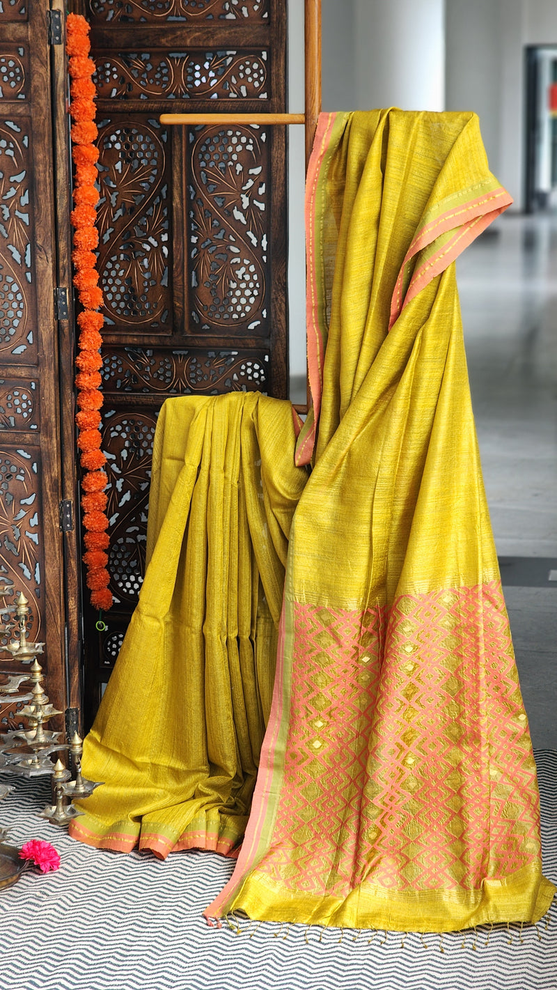 Mustard gold matka silk saree with coral pink border.