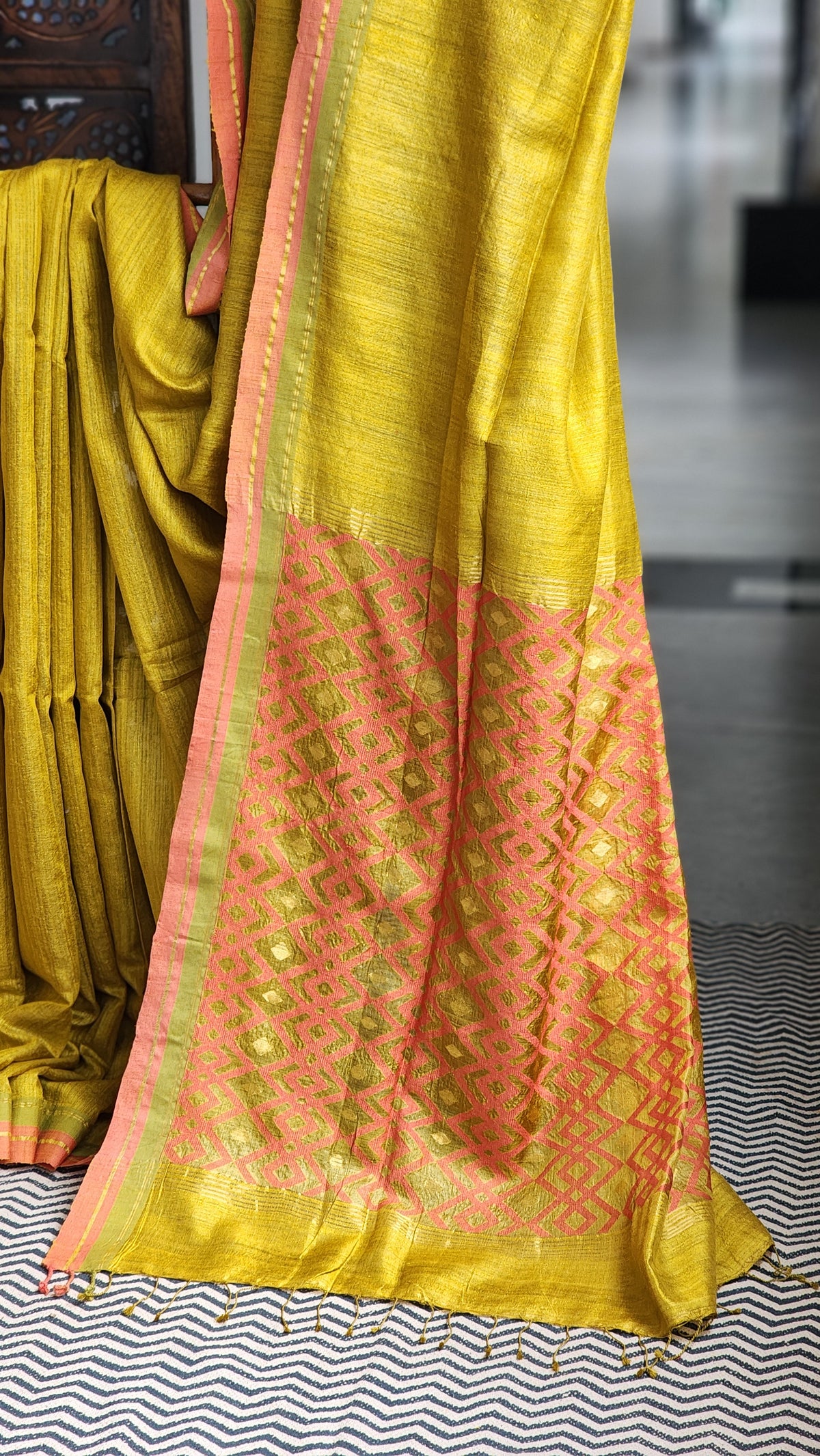 Mustard gold matka silk saree with coral pink border.